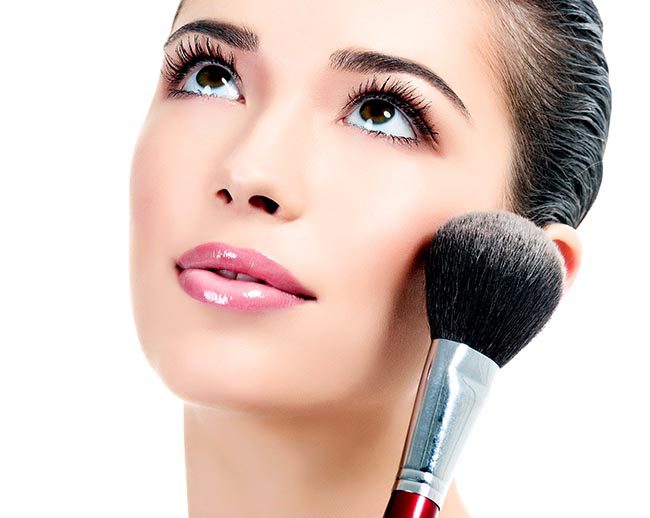 Pretty woman with a cosmetic brush, white background